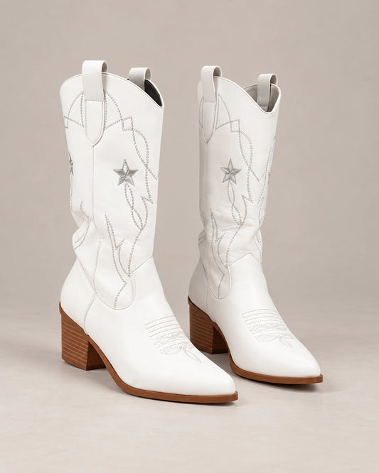 Angled view of white Western boots showing pointed toes, star stitching and block heels