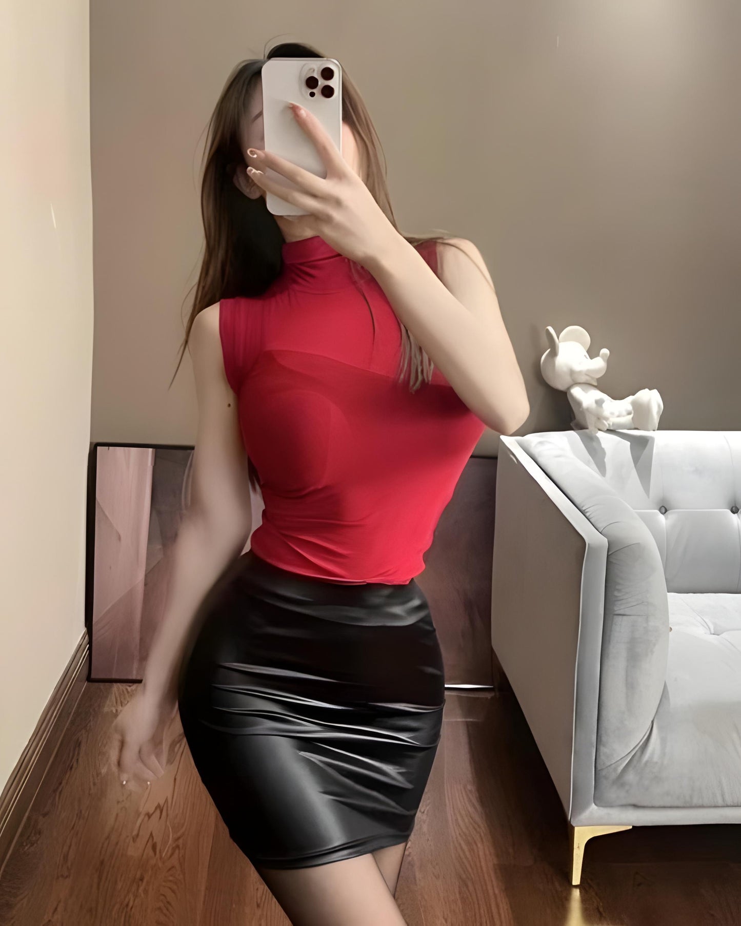 Black leather mini skirt with bodycon fit and latex wet look. close up