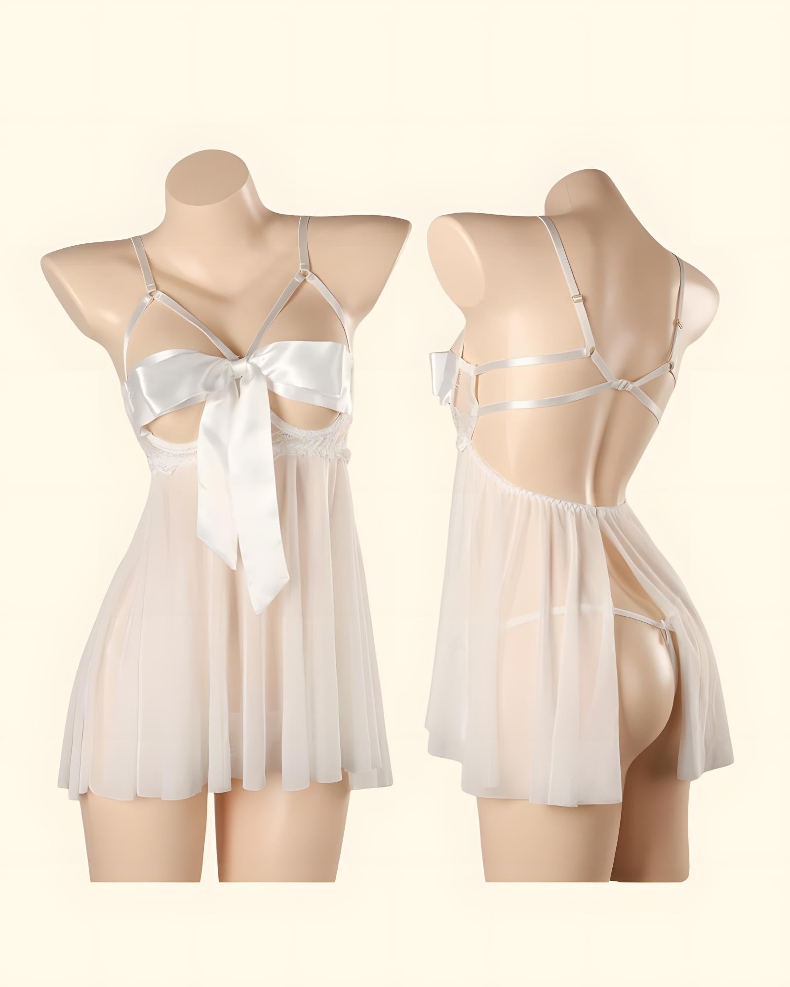 A sheer babydoll lingerie dress shown on two beige mannequin torsos against a warm cream background. The front view shows thin straps, a large white satin bow at the bust, and a flowing semi-transparent skirt.