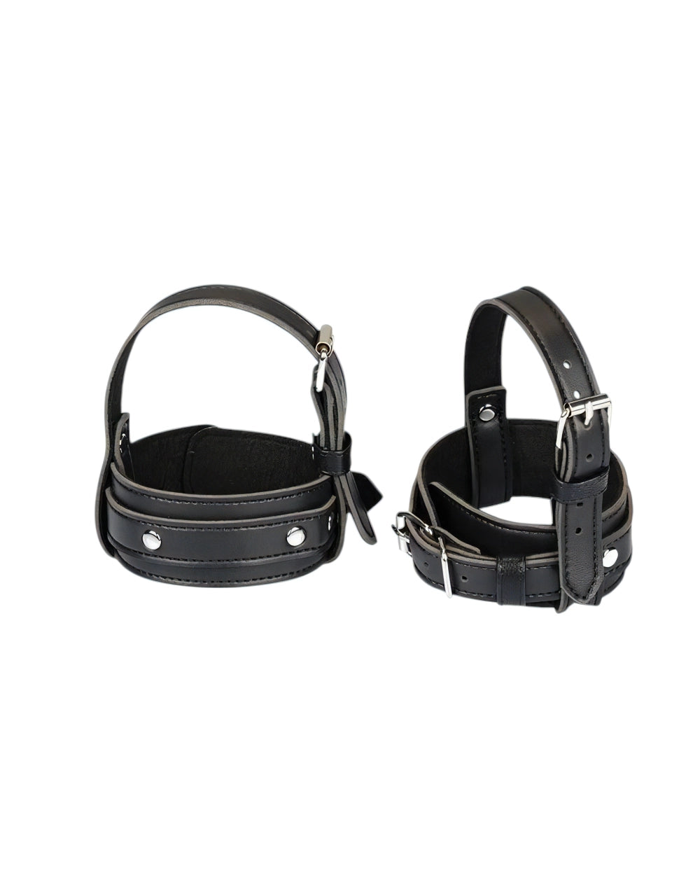 Two black leather restraint cuffs with silver metal buckles and rivets, displayed side-by-side on a plain white background.
