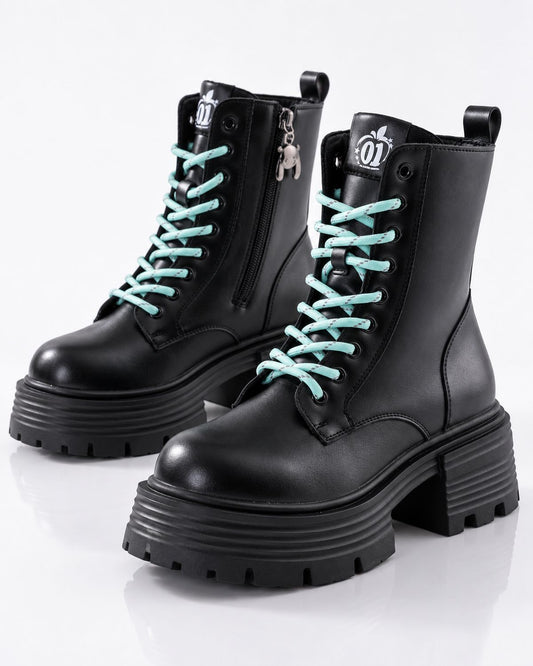 A pair of black leather platform combat boots with chunky lug soles and light blue laces, shown on a reflective white studio background.