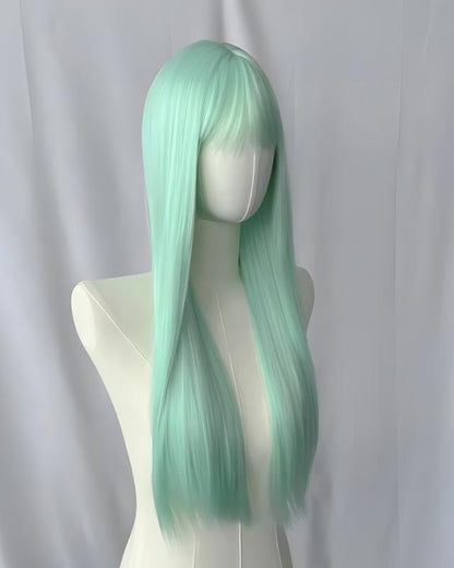 Mint green wig on a mannequin head against a white background