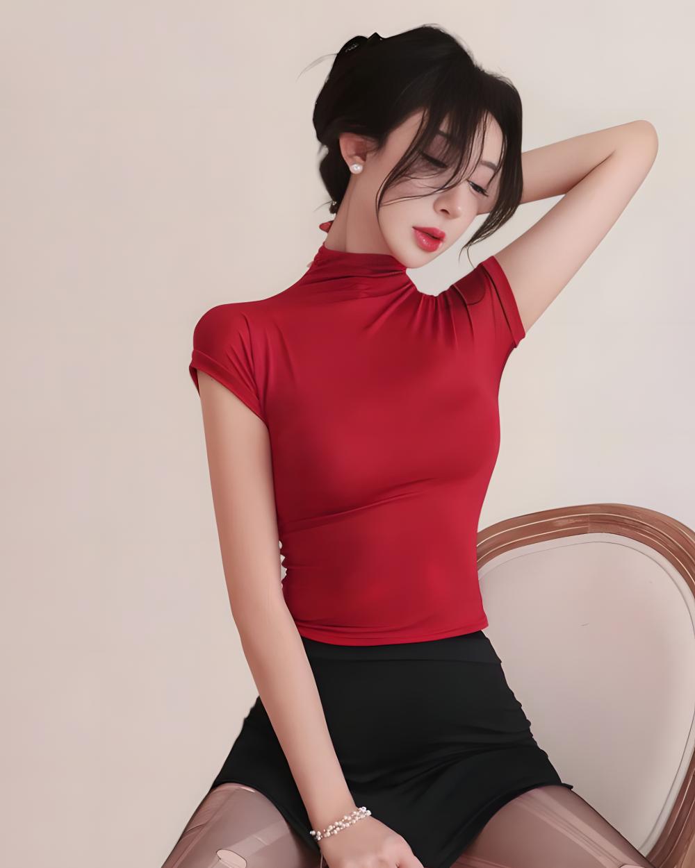 Woman wearing a red top and black skirt against a plain background