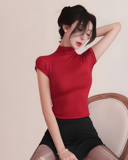 Woman wearing a red top and black skirt against a plain background