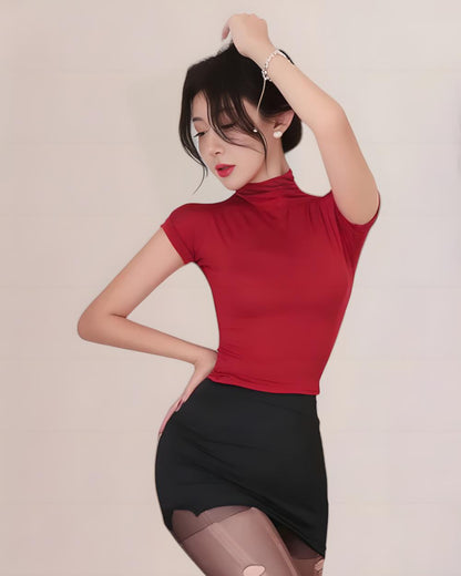 Woman wearing a red top and black skirt against a plain background