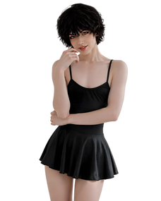 A model wearing a black spaghetti-strap camisole top and a matching black pleated mini skirt, set against a solid white background.
