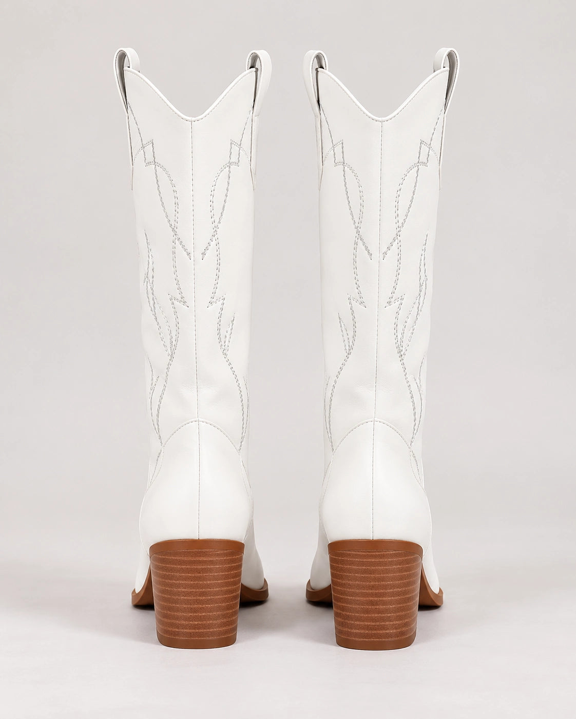 Rear view of white mid-calf Western boots with brown stacked heels