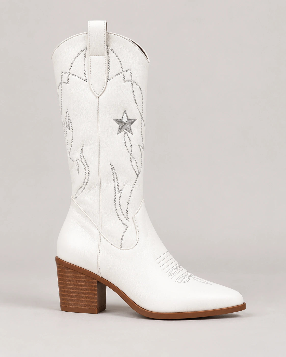 Side profile of a white pointed toe cowboy boot with star embroidery and block heel