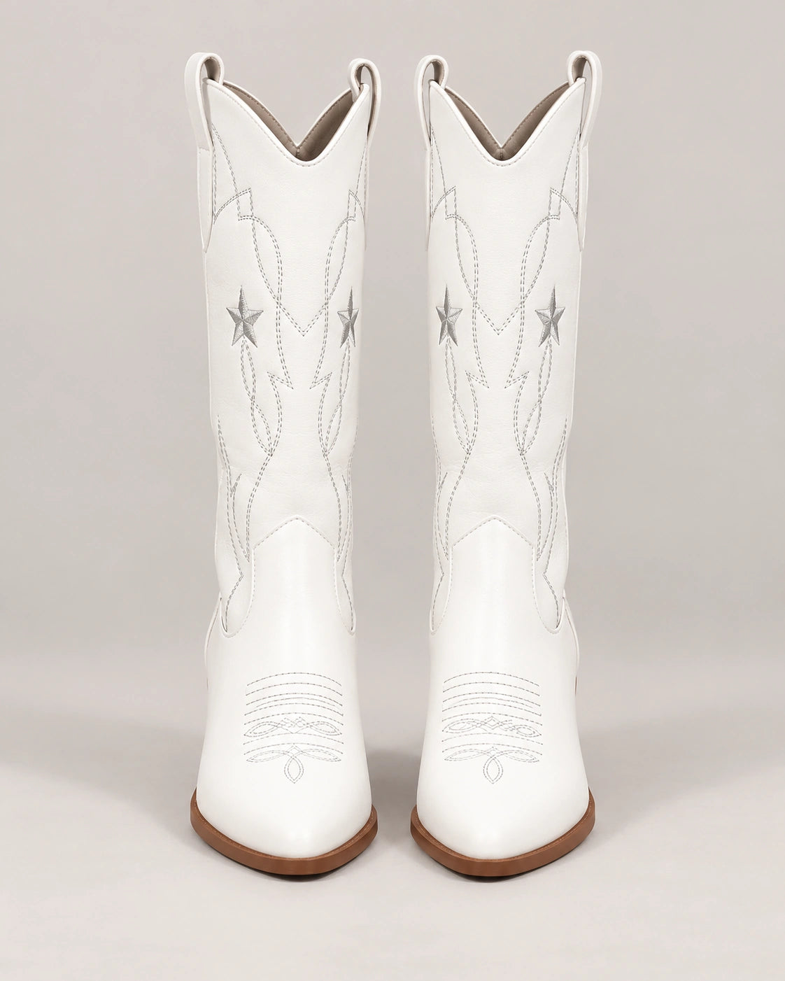 Front view of white star embroidered mid-calf cowboy boots with brown heels